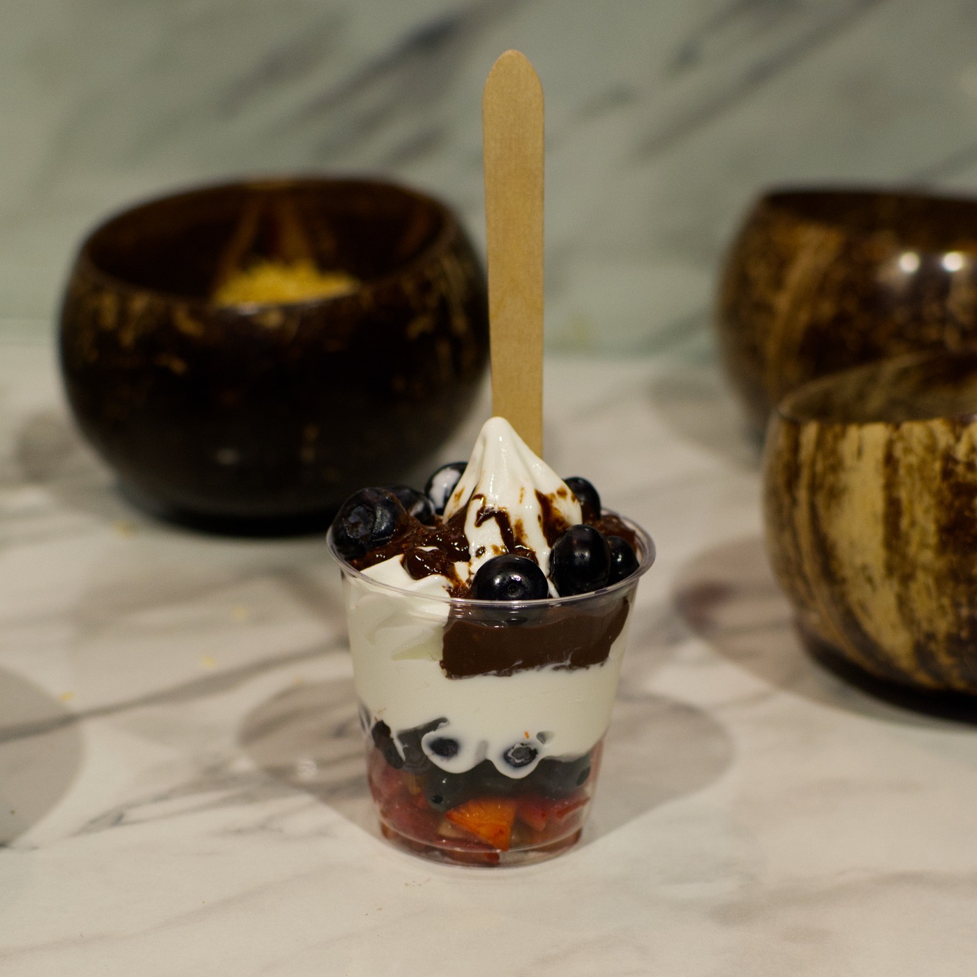 Helado suave sabor yogurt de nube con arándano, fresa y salsa de chocolate
